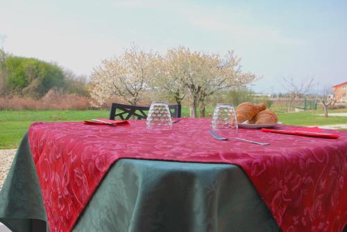 a red table with bread and glasses on it at B&B da Rosy in Lazise
