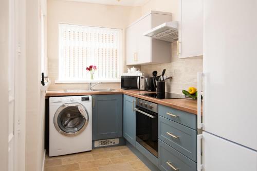 a kitchen with a washing machine and a dishwasher at Cosy Seaside Hideaway in Northumberland with 1 pet welcome from November to March in Newbiggin-by-the-Sea