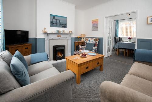 a living room with a couch and a fireplace at Cosy Seaside Hideaway in Northumberland with 1 pet welcome from November to March in Newbiggin-by-the-Sea