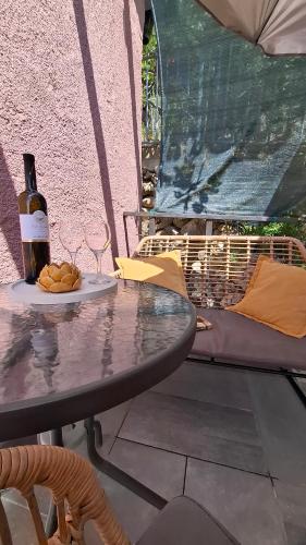 un tavolo con una bottiglia di vino e un piatto di cibo di Agave apartments a Stara Baška