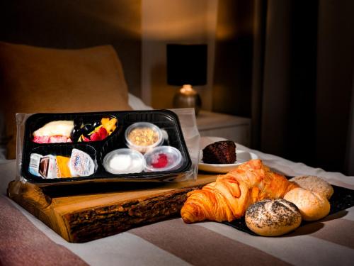 un plateau de nourriture avec du pain et des viennoiseries sur un lit dans l'établissement Apartamenty i Studia HERBARIUM, à Cracovie