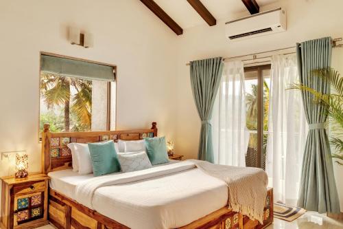Un dormitorio con una cama grande y una ventana en Luxury 3bhk penthouse Candolim beach 10 mins, en Goa