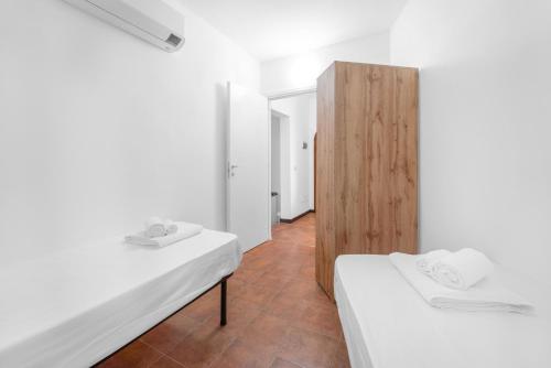 a white room with two beds and a wooden partition at -Vista Mare- Casa con piscina e spiaggia a 300 MT in Liscia di Vacca