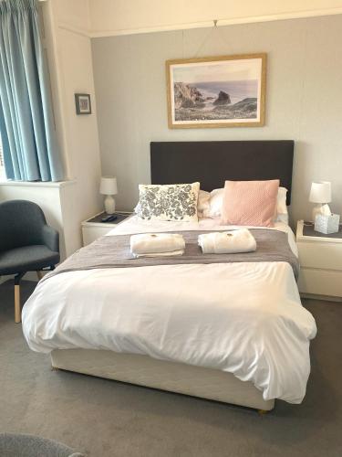 a bedroom with a large bed with two pillows on it at En-suite nook near forest & sea, great value with fridge, microwave and TV in Lymington