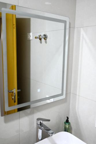 a mirror above a sink in a bathroom at Fly Rooms in Krujë