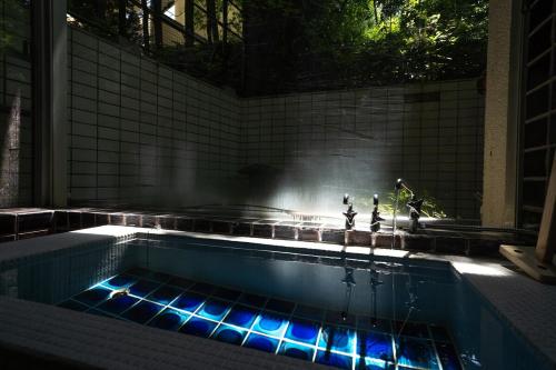 a swimming pool with blue lights in a tiled room at 2 Onsens in-Villa #Private hot-spring Villa in Hakone in Hakone