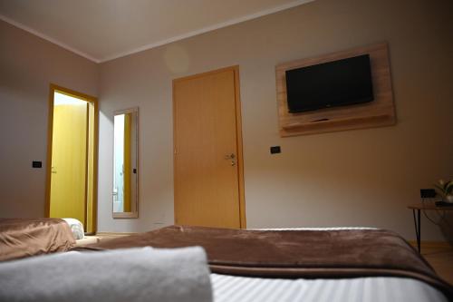 a bedroom with a bed and a television on the wall at Fly Rooms in Krujë