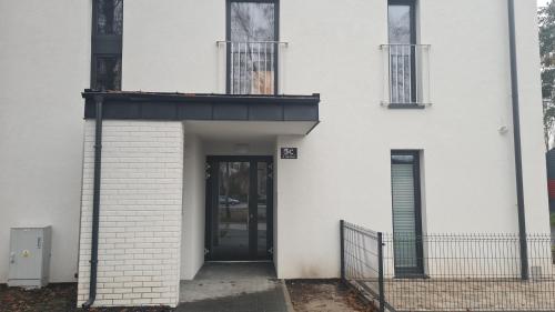 an entrance to a white building with a door at Zuzia Apartments in Chojna
