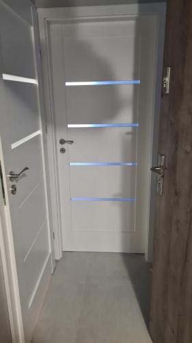 a white door in a room with a hallway at Zuzia Apartments in Chojna