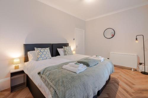 a bedroom with a large bed with towels on it at 2-bedroom, Sleeps 4, long stays in Brighton & Hove