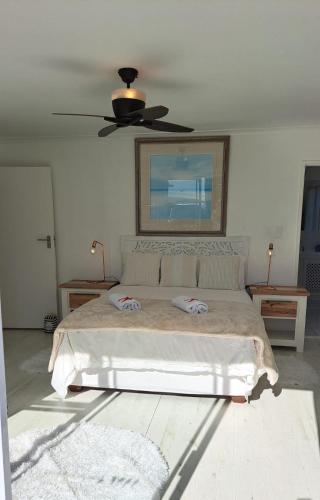 a bedroom with a bed and a ceiling fan at The Starfish View in Grotto Bay