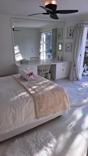 a bedroom with a large bed with a ceiling fan at The Starfish View in Grotto Bay