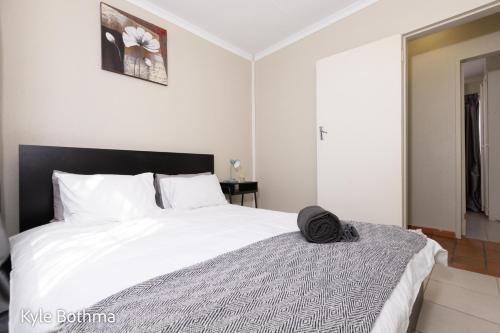 a bedroom with a white bed with a hat on it at Midrand Premium Villa at Noordwyk in Midrand