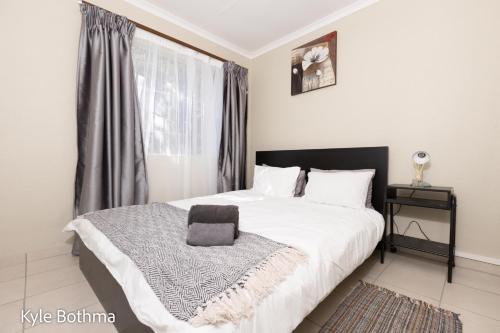 a bedroom with a white bed with a black headboard at Midrand Premium Villa at Noordwyk in Midrand
