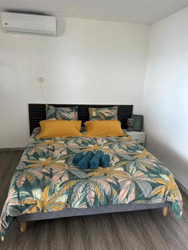 a bedroom with a bed with two blue pillows at Zèl O Van in Petite Île