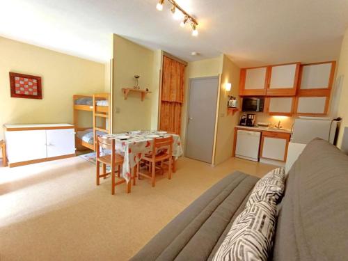 un salon avec une table et une cuisine dans l'établissement T2 Cabine avec Balcon au Cœur des Thermes - 6 Pers, Parking, Proche Télécabines, Équipé Tout Confort - FR-1-457-230, à Saint-Lary-Soulan
