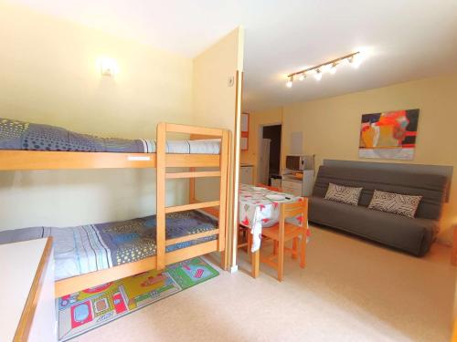 une chambre avec deux lits superposés et un canapé dans l'établissement T2 Cabine avec Balcon au Cœur des Thermes - 6 Pers, Parking, Proche Télécabines, Équipé Tout Confort - FR-1-457-230, à Saint-Lary-Soulan