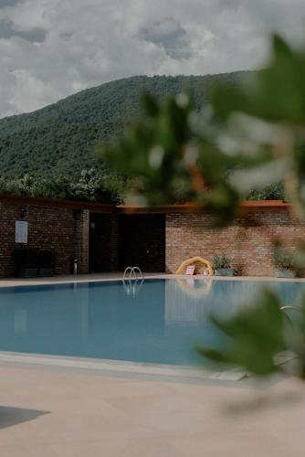 a swimming pool in front of a building with a mountain at Chateau Artwine in Art'ana