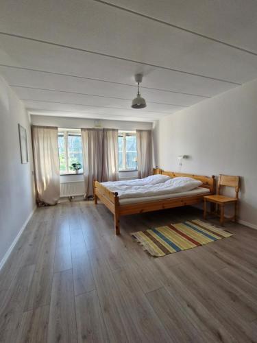 a bedroom with a bed and two windows at Nordbakks holiday apartments in Frostviken, Gäddede in Gäddede