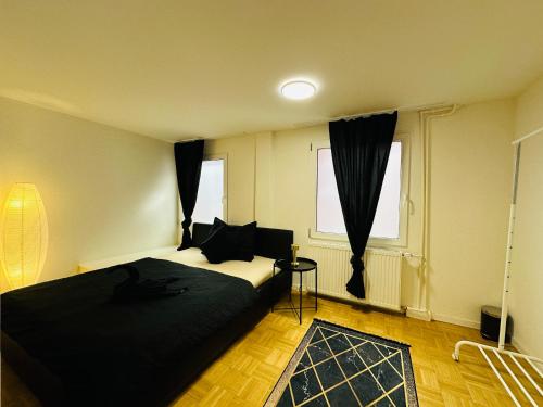 a bedroom with a black bed and a window at Exklusives Apartment mit traumhaftem Seeblick & Balkon in Rorschach