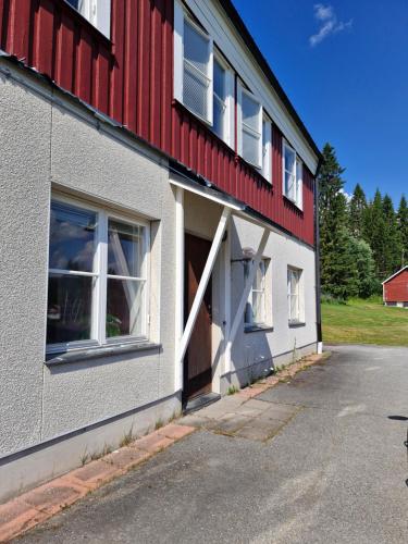 a red and white building with a garage at Nordbakks holiday apartments in Frostviken, Gäddede in Gäddede