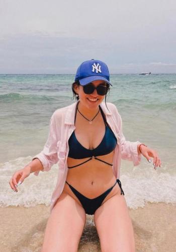 a woman in a bikini and a hat on the beach at Brisas del Mar Barú in Playa Blanca