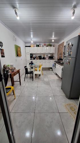 eine große Küche mit Tisch und Kühlschrank in der Unterkunft Condomínio Liberdade in Sao Jose do Rio Preto