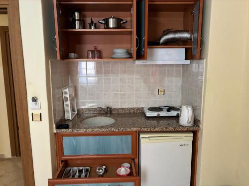 a small kitchen with a sink and a counter at Sailorson Apart Hotel in Alanya
