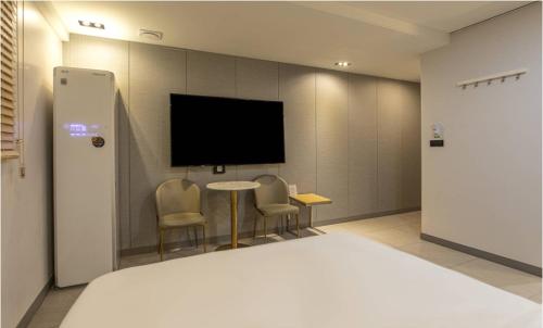 a hotel room with a bed and a flat screen tv at Hotel 99 Prestige in Seoul
