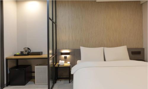 a bedroom with a large bed and a desk at Hotel 99 Prestige in Seoul