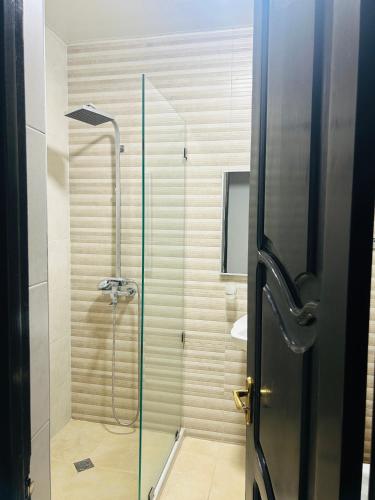 a bathroom with a shower with a glass door at Porta Hostel in Batumi
