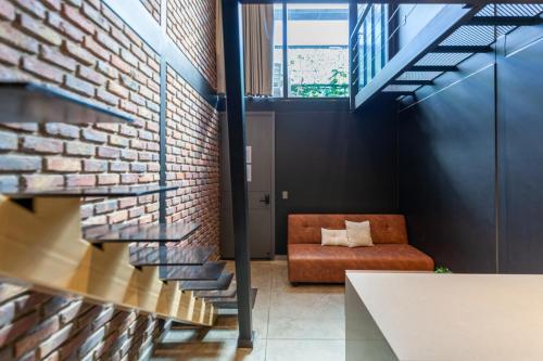 a living room with a couch and a brick wall at Blok Living in Medellín