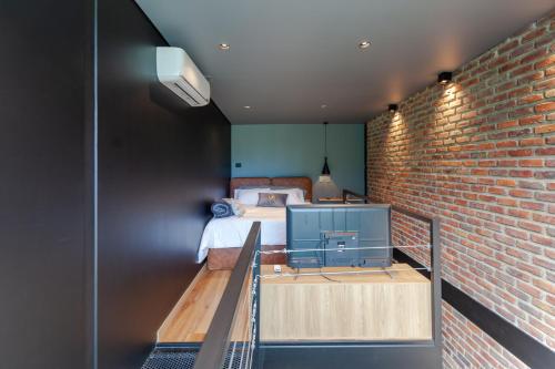 a bedroom with a bed and a brick wall at Blok Living in Medellín
