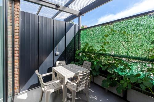 a balcony with a table and chairs and a vertical garden at Blok Living in Medellín