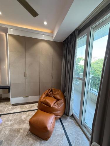 a brown bean bag chair in a room with a window at Atrium by Bali in New Delhi