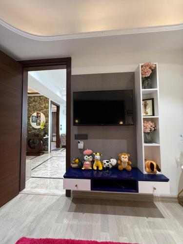 a living room with a fish tank with stuffed animals at Atrium by Bali in New Delhi