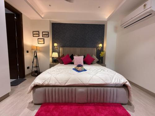 a bedroom with a large bed with pink pillows at Atrium by Bali in New Delhi