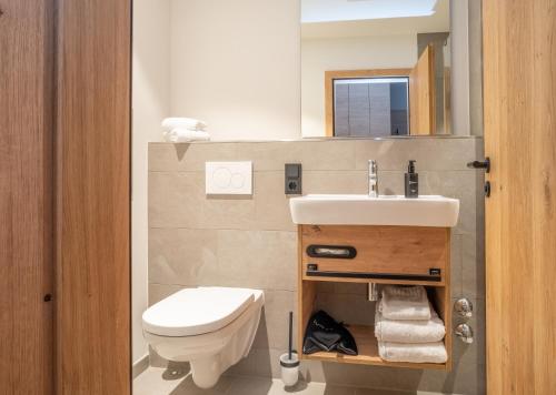 a bathroom with a sink and a toilet and a mirror at Gasthof zur Post in Bad Wiessee