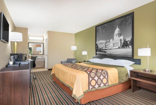 a hotel room with a large bed and a desk at Super 8 by Wyndham Bryant Little Rock Area in Bryant