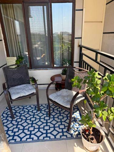 two chairs and a table on a balcony with plants at The Frunze One in Bishkek