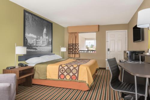 een hotelkamer met een bed en een bureau bij Super 8 by Wyndham Bryant Little Rock Area in Bryant