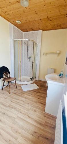 a bathroom with a shower and a sink and a tub at Foreshore House in New Romney