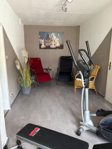 a room with a gym with a treadmill and chairs at Hotel-Pension Bergkranz in Braunlage