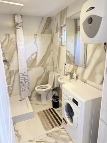 a bathroom with a sink and a washing machine in it at IsTh Wave House in Vadu