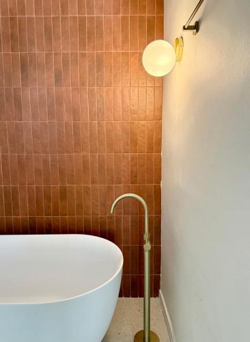 a bath tub in a bathroom with a lamp at Old Town Boutique Suites in Lefkada Town
