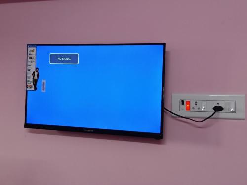 a tv with a blue screen on a wall at Raja Home stay in Tiruvannāmalai