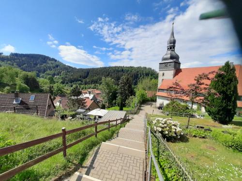 a church with a steeple in a small village at Ferienwohnung Auf gut Glück, Lautenthal, Harz in Langelsheim