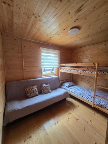 a room with a couch and two bunk beds at Siodemkacamp Karwia in Karwia