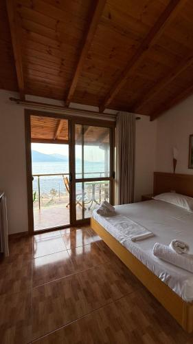 a bedroom with a bed with a view of the ocean at Hotel Ramosaco, Radhimë, Vlorë in Vlorë