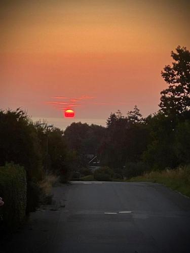 a sunset over a road with the sun in the sky at Villa 16 in Kivik